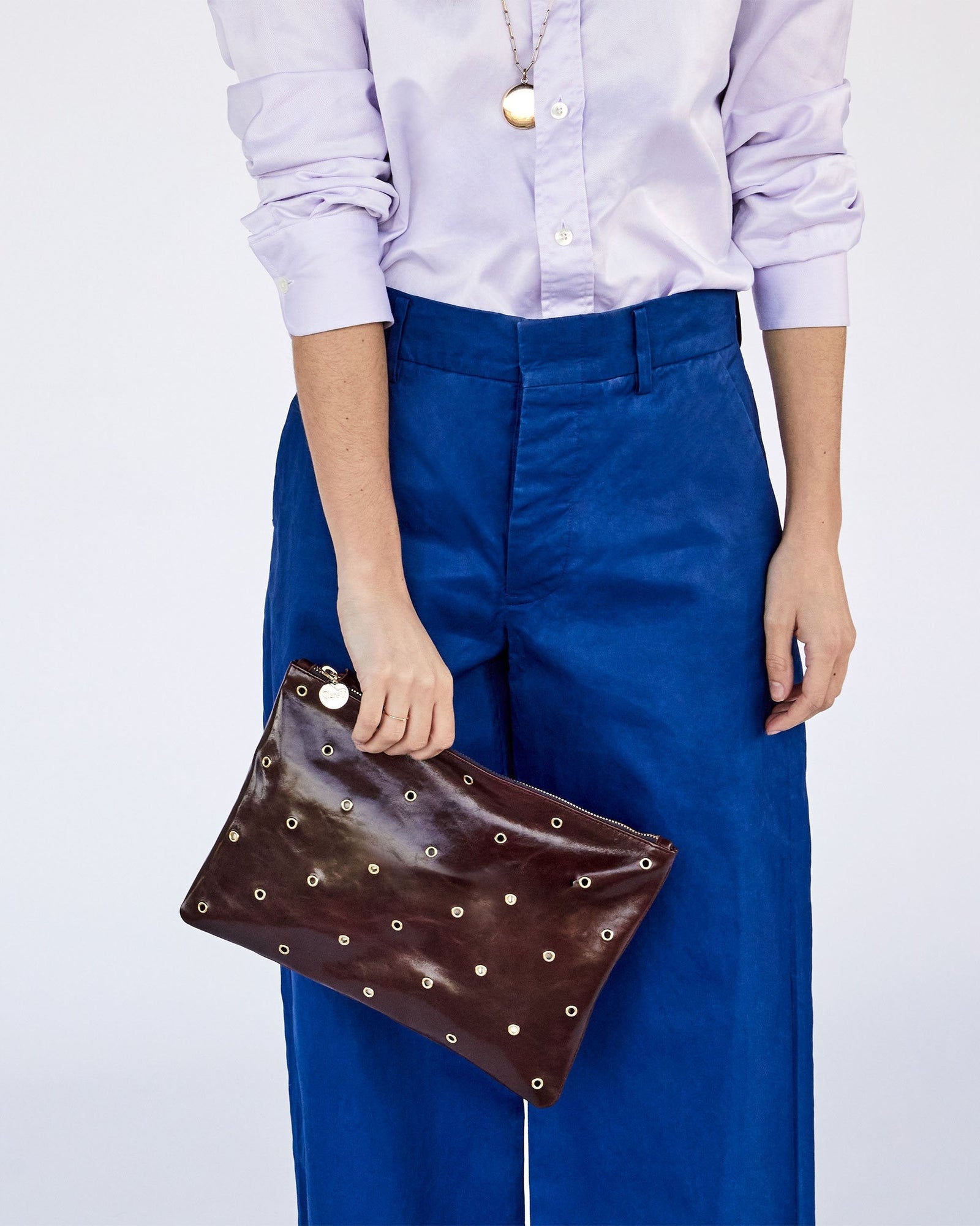 Frannie Holding the Walnut w/ Grommets Flat Clutch with Tabs with One Hand