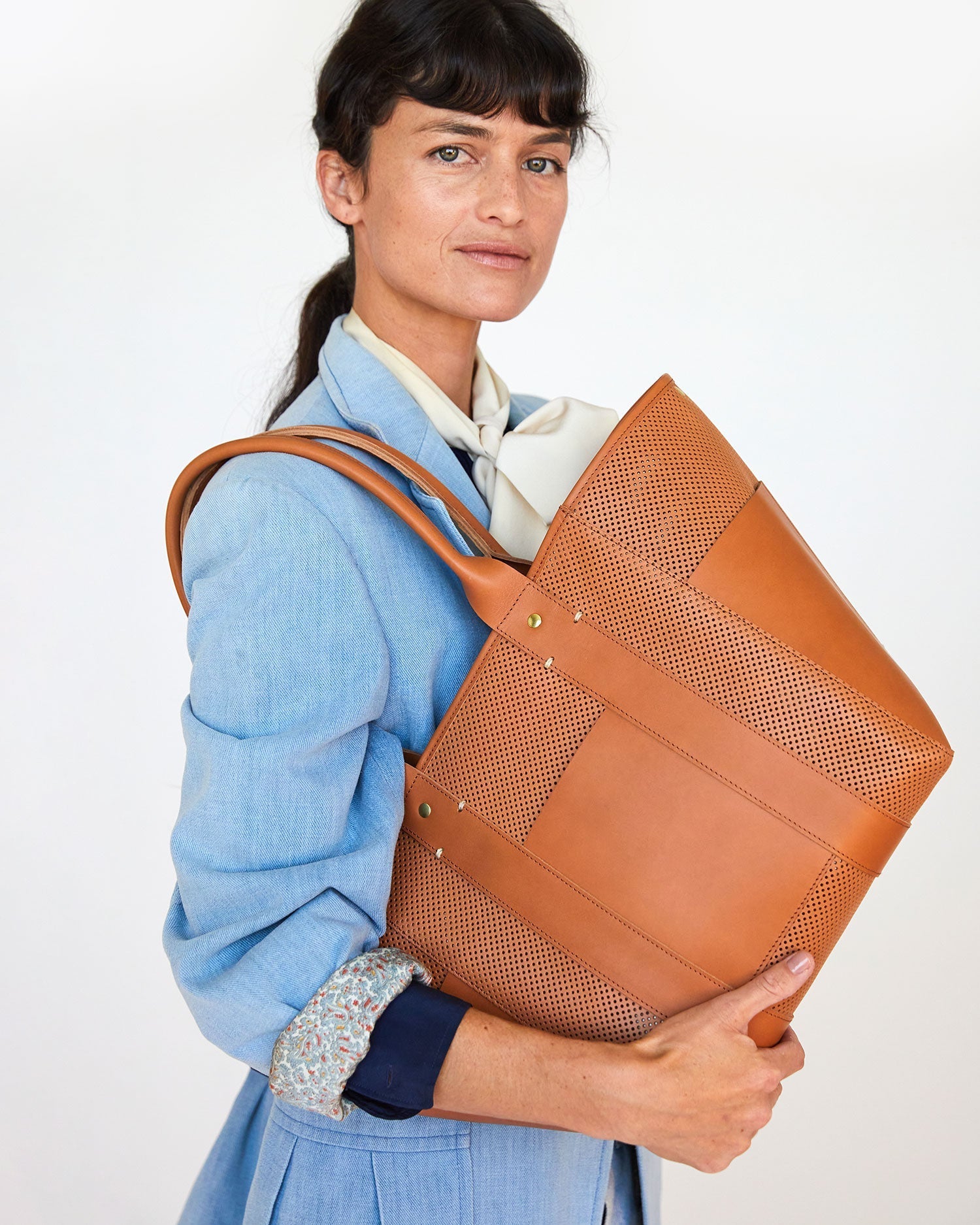 danica in a blue blazer holding the Cuoio Perf Le Box Tote on her shoulder