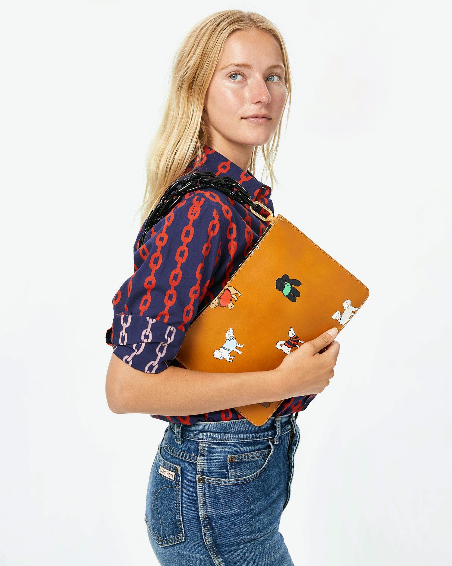 natalie with the sleeves rolled up on the Navy and Poppy Chains Felix Blouse with the cuoio with paco and friends flat clutch on her shoulder with the black resin shortie strap