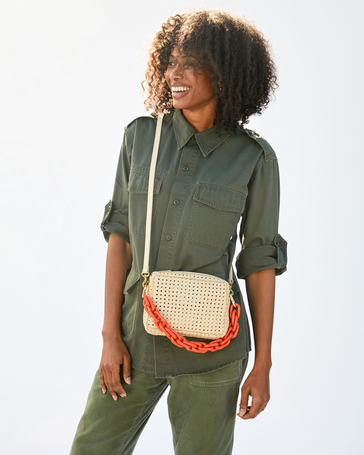 mecca smiling with the Cream Rattan Midi Sac on crossbody with the neon orange resin shortie strap attached