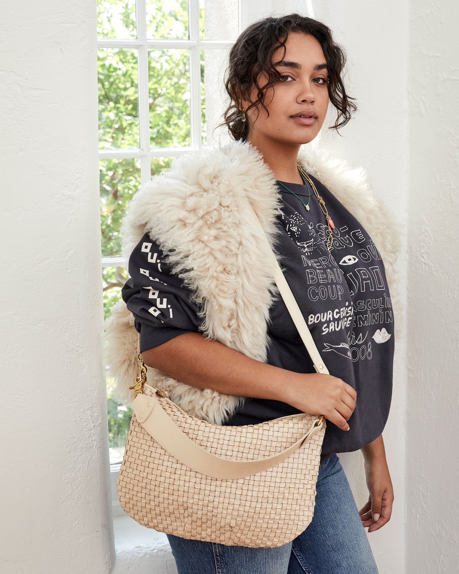 Claudia Wearing the Cream Woven Checker Moyen Messenger with its Crossbody Strap on Her Shoulder