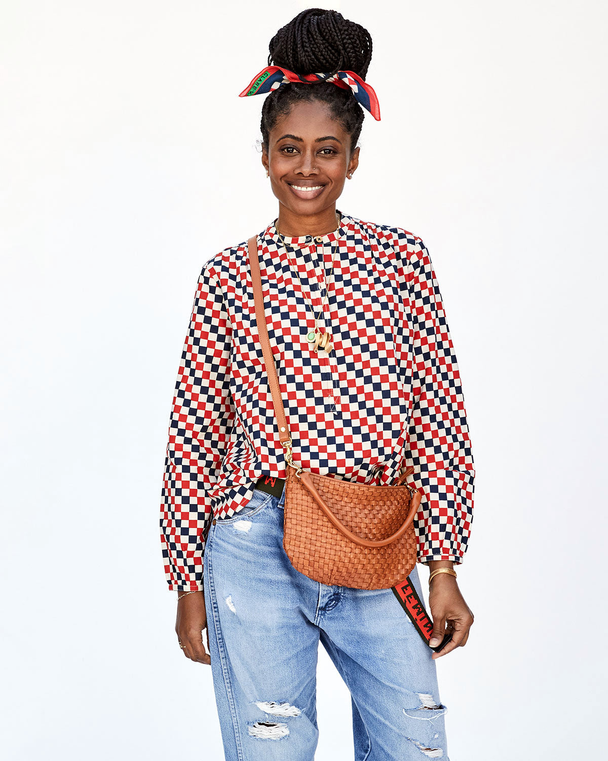 Mecca Wearing Jeans and the Red & Navy Checker St. Martin Top with the Natural Woven Checker Petit Moyen Worn Crossbody
