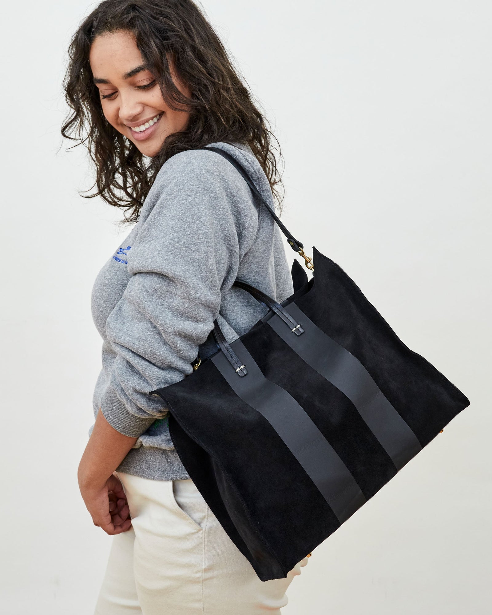Claudia Wearing the  Black Suede with Matte Black Racing Stripes Simple Tote on Her Shoulder